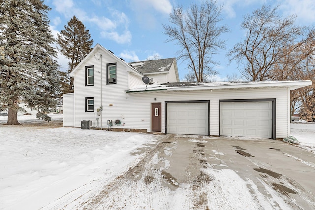 view of property with central AC unit and a garage