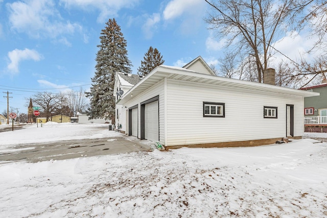 snow covered property featuring a garage