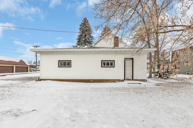 view of snow covered back of property