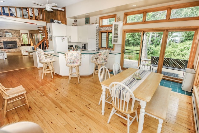 dining space with light hardwood / wood-style floors, ceiling fan, and a wealth of natural light