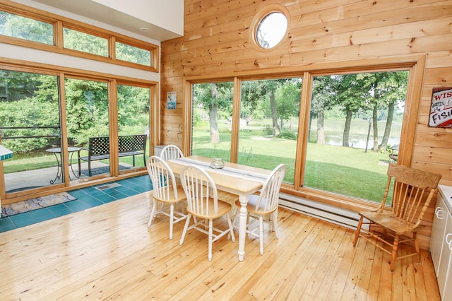 sunroom / solarium featuring baseboard heating, a water view, and a wealth of natural light