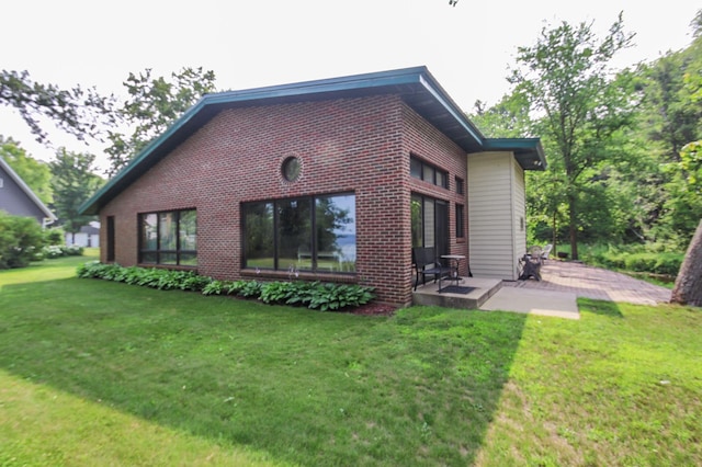 back of property with a patio and a lawn