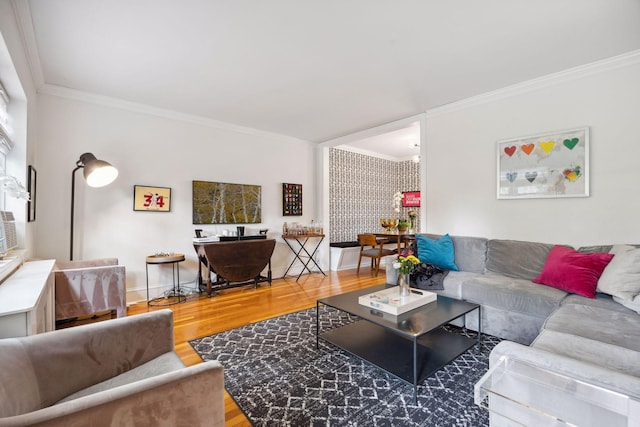 living room with wood-type flooring, ornamental molding, and an inviting chandelier