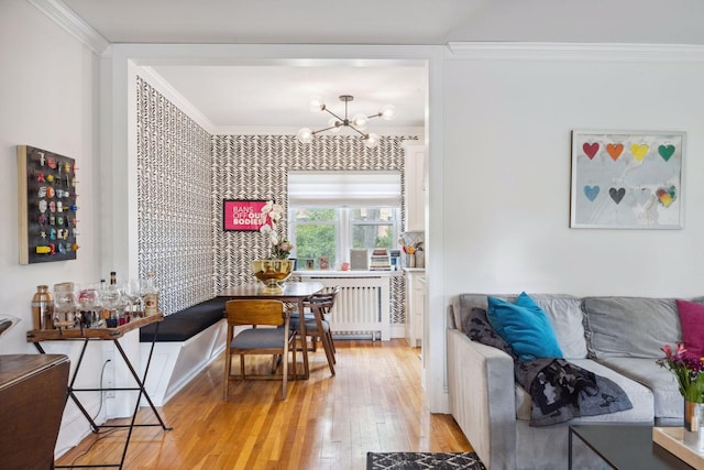 dining room with light hardwood / wood-style floors, crown molding, radiator heating unit, and a notable chandelier