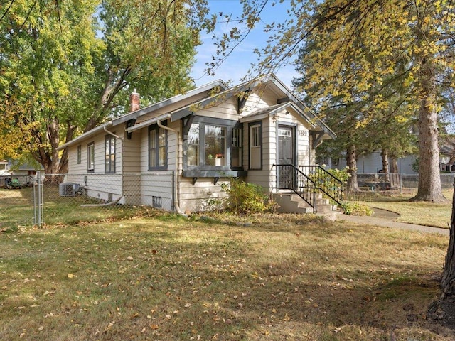 bungalow-style home featuring a front lawn and central AC unit