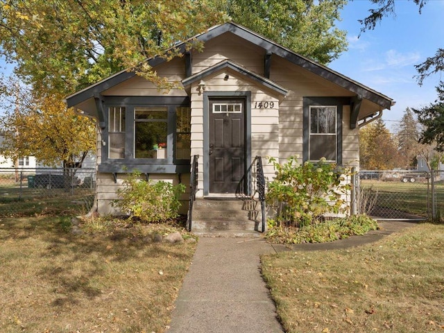 bungalow-style house with a front lawn