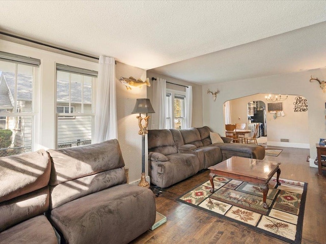 living room with a textured ceiling and dark hardwood / wood-style flooring