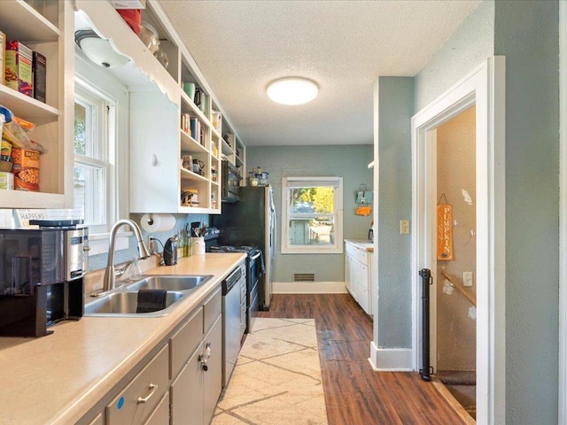 kitchen featuring a textured ceiling, sink, stainless steel appliances, and dark hardwood / wood-style flooring