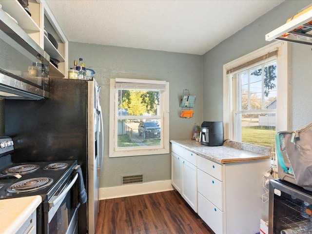 kitchen featuring white cabinets, dark wood-type flooring, plenty of natural light, and electric stove