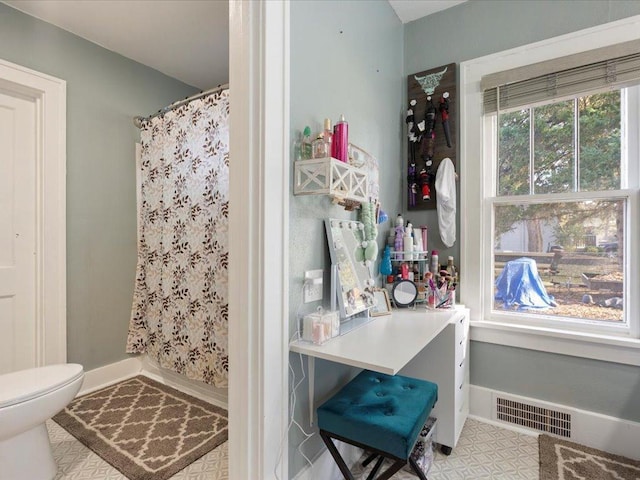 bathroom featuring a shower with shower curtain and toilet