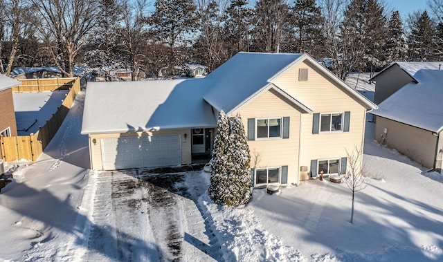 snow covered rear of property with a garage