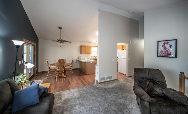 living room featuring hardwood / wood-style floors, ceiling fan, and high vaulted ceiling