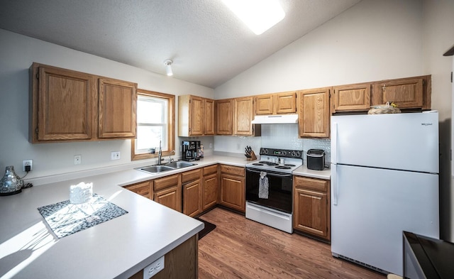 kitchen with white appliances, a textured ceiling, sink, high vaulted ceiling, and hardwood / wood-style floors