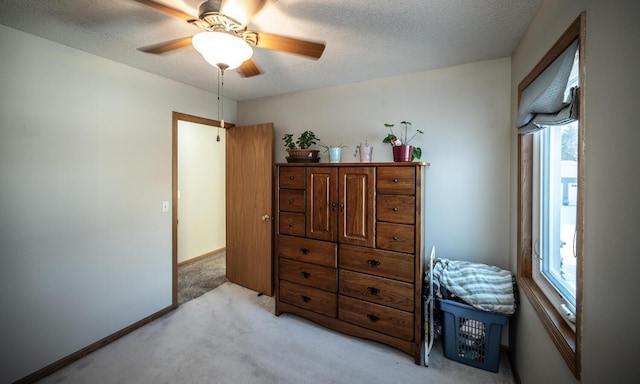 carpeted bedroom featuring multiple windows, ceiling fan, and a textured ceiling