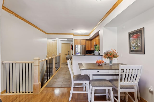 dining room featuring light wood-type flooring and crown molding