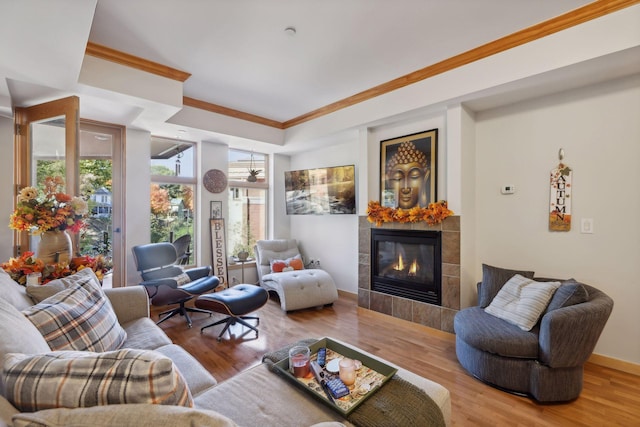 living room with ornamental molding, a fireplace, and wood-type flooring