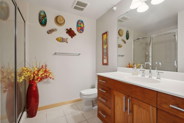 bathroom featuring vanity, tile patterned floors, toilet, and a shower with door