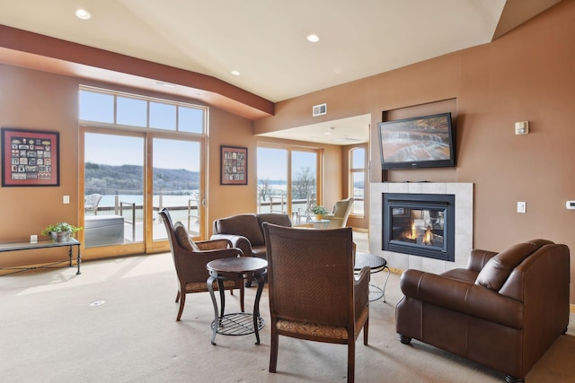 carpeted living room featuring a tile fireplace