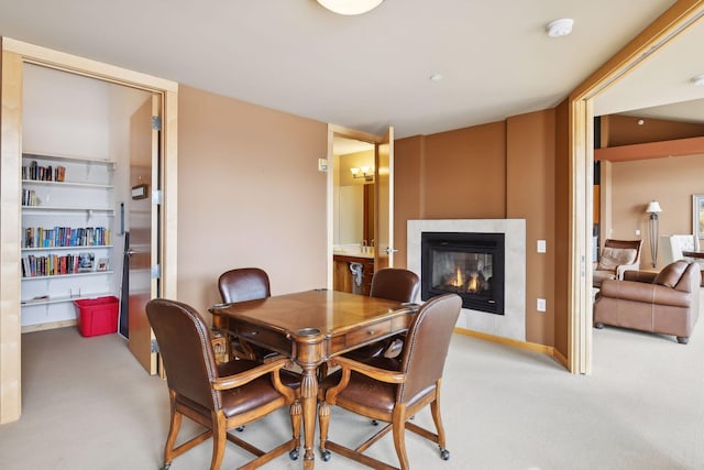 dining room with a tile fireplace and light carpet