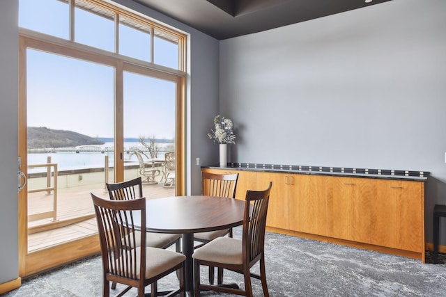 dining space with a water view and carpet floors