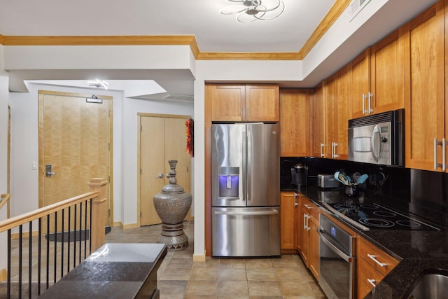 kitchen with brown cabinets, tasteful backsplash, dark stone counters, appliances with stainless steel finishes, and crown molding