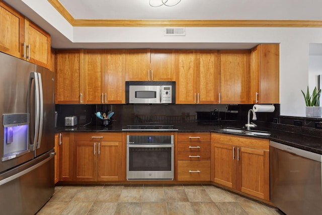 kitchen with brown cabinets, visible vents, appliances with stainless steel finishes, and a sink