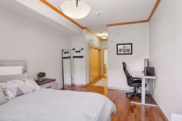 bedroom with baseboards, wood finished floors, and ornamental molding