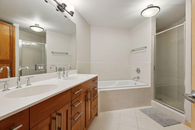 bathroom with a sink, a stall shower, double vanity, and tile patterned flooring