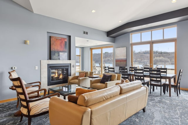 living area with a tiled fireplace, visible vents, recessed lighting, and baseboards