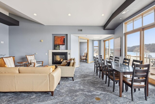 carpeted dining space with recessed lighting, visible vents, and a glass covered fireplace