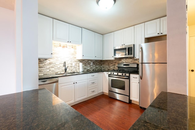 kitchen with dark hardwood / wood-style floors, white cabinetry, sink, and appliances with stainless steel finishes