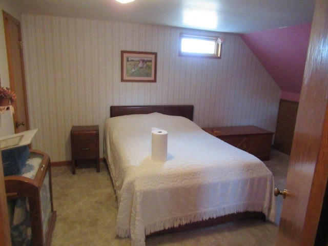 bedroom featuring light carpet and vaulted ceiling