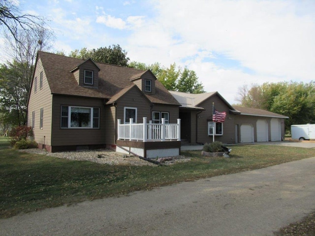 cape cod-style house featuring a front lawn and a garage