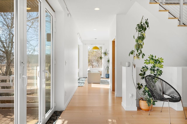 hall featuring baseboards, stairway, recessed lighting, and light wood-style floors