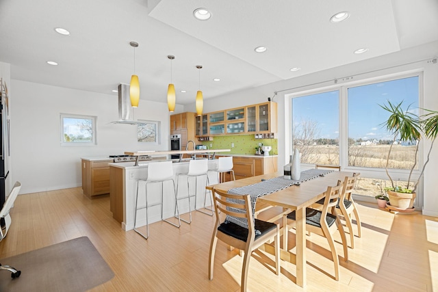 dining room with baseboards, light wood-type flooring, and recessed lighting