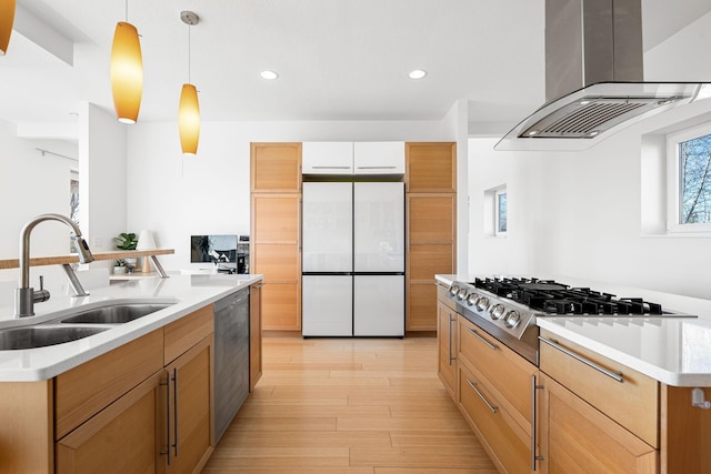 kitchen with decorative light fixtures, island exhaust hood, appliances with stainless steel finishes, a sink, and an island with sink