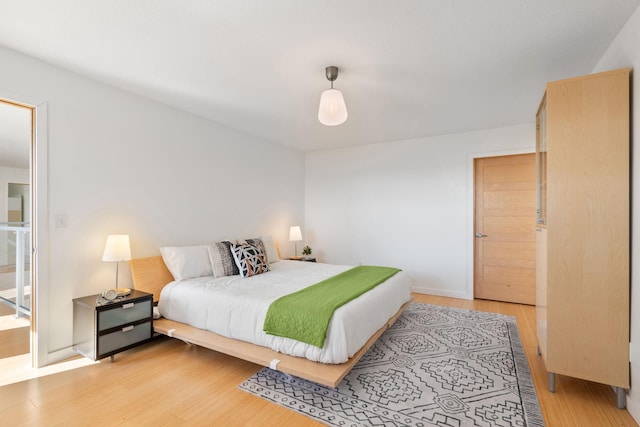 bedroom featuring light wood-style floors and baseboards