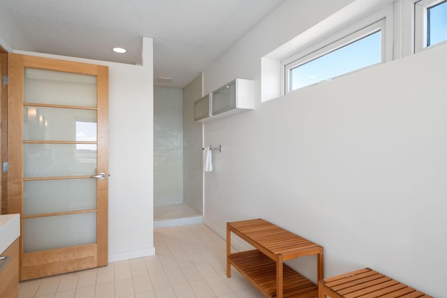 bathroom featuring vanity, baseboards, and a walk in shower