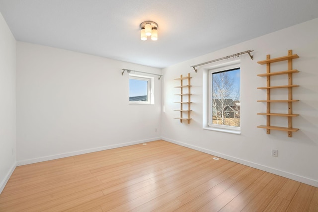 unfurnished room with light wood-style floors and baseboards