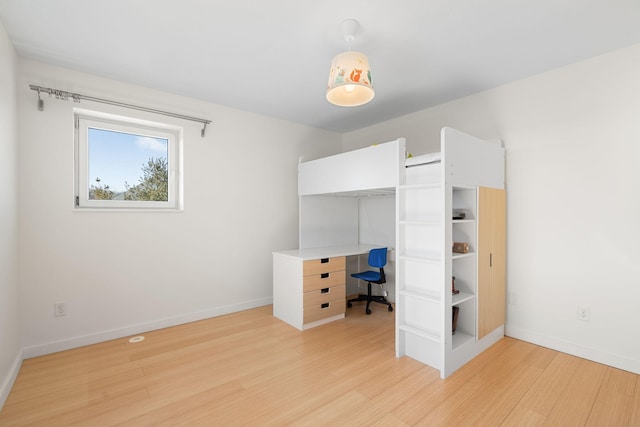 unfurnished bedroom featuring light wood-style floors and baseboards