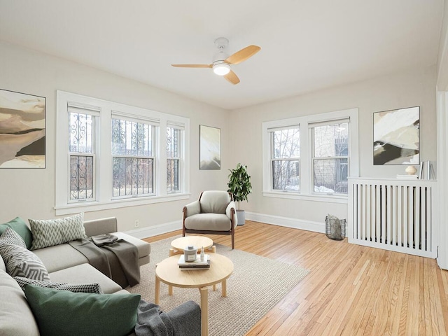 living room featuring ceiling fan, light hardwood / wood-style flooring, and plenty of natural light