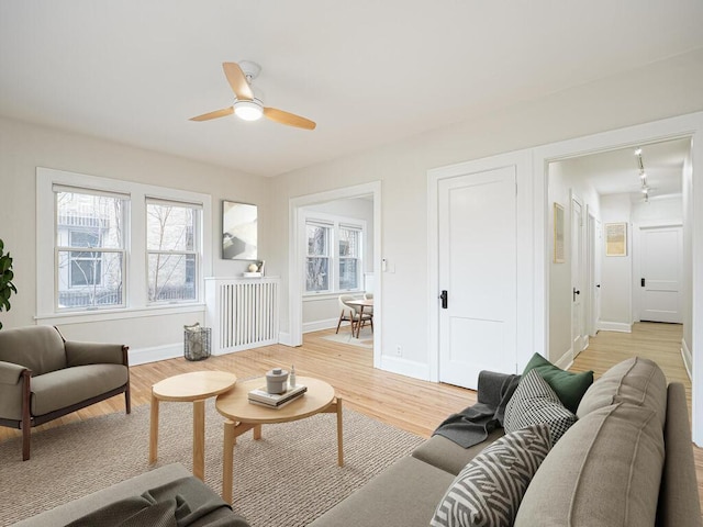 living room with light wood-type flooring and ceiling fan