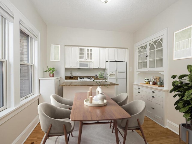 dining room featuring sink and light hardwood / wood-style flooring