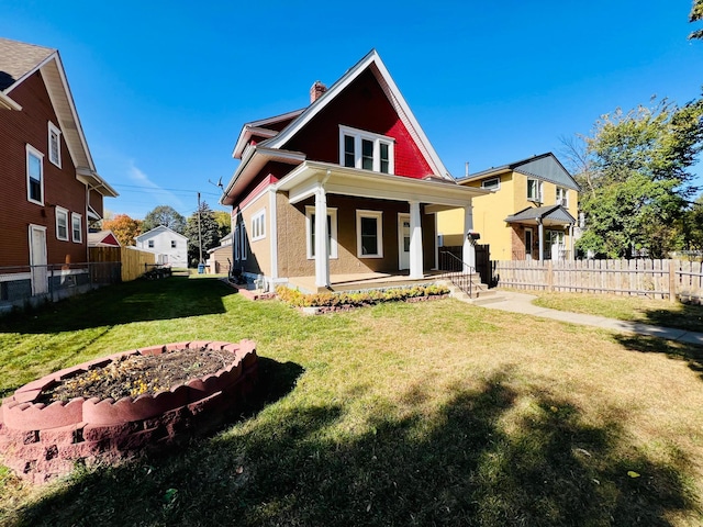 back of property with a yard and covered porch