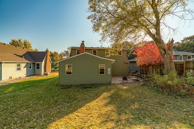 rear view of house featuring a patio and a lawn