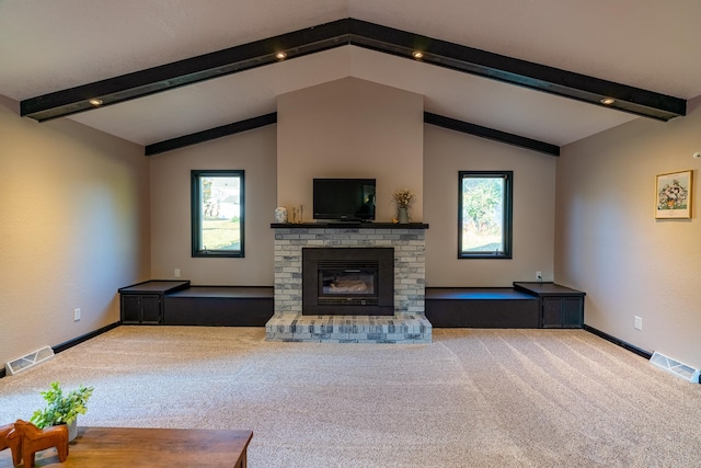 unfurnished living room with a wealth of natural light, vaulted ceiling with beams, and carpet flooring