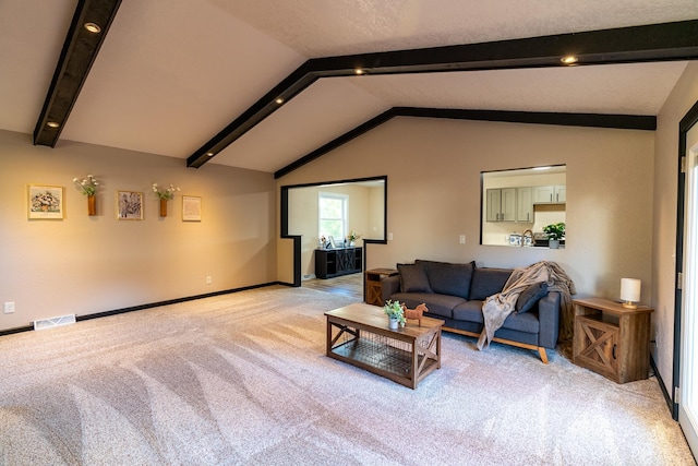 carpeted living room featuring vaulted ceiling with beams