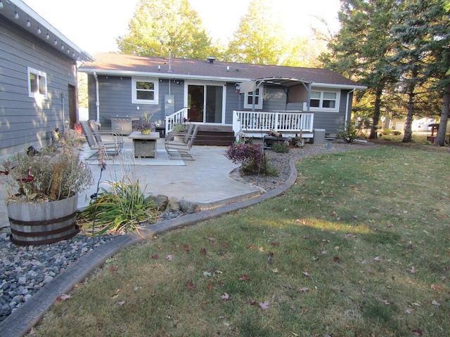 back of property featuring a patio area, a deck, and a lawn