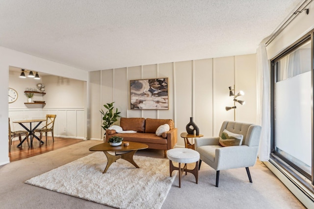 living room with a textured ceiling, a baseboard radiator, and light colored carpet