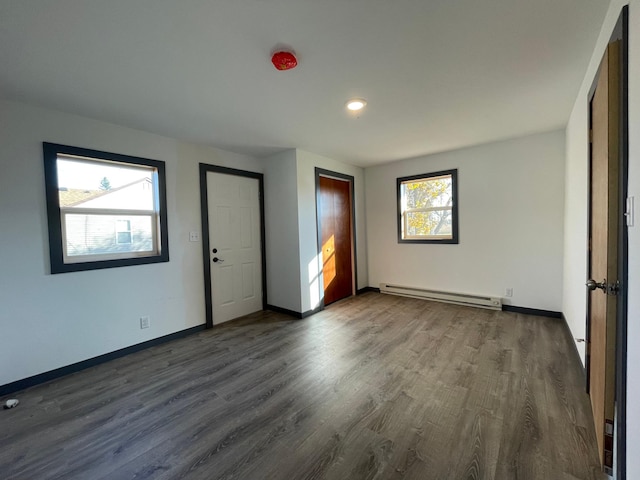 unfurnished bedroom featuring a baseboard radiator and dark hardwood / wood-style flooring